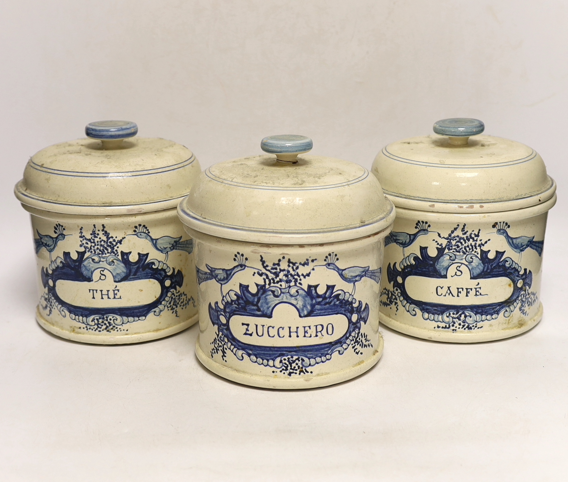 Three French cream and blue glazed storage jars and covers, Caffé, Thé and Zucchero, 18cm high